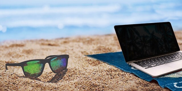 sunglasses and laptop at the beach